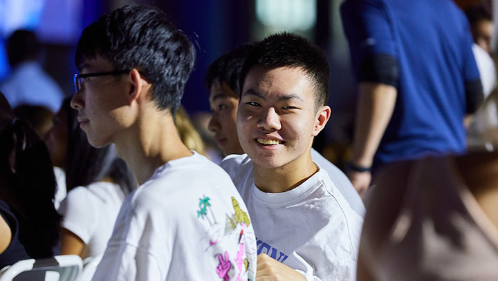 Smiling student in white t-shirt at an event