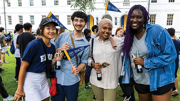 group of students on Emory Quad holding Emory pennants